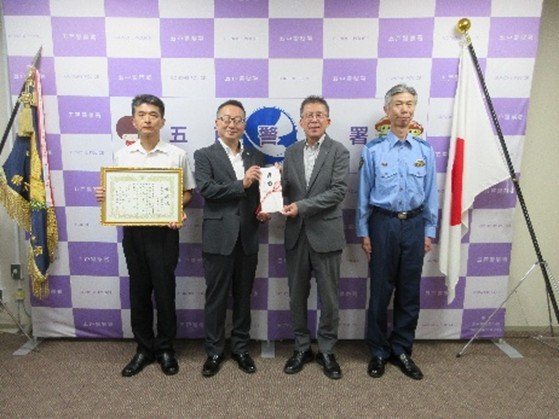 記念撮影に収まる廣島専務（左）